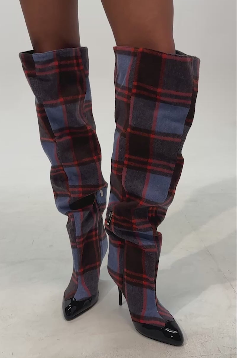 Video of woman modeling the AZALEA WANG LOCHANA PURPLE MULTI PLAID STILETTO BOOT, which features knee-high stiletto heels and a vibrant purple multi-plaid pattern with pointed black patent leather toes
