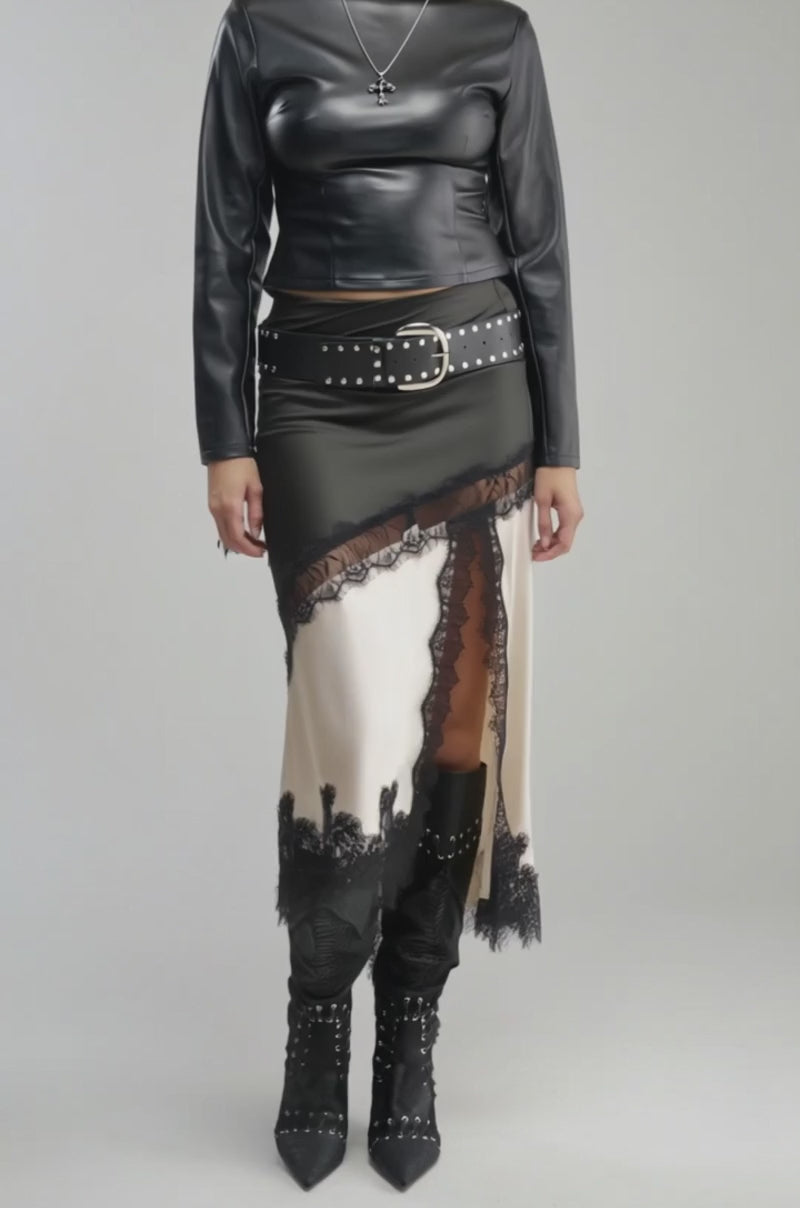 Video of a woman modeling the LEA LACE UP PU TOP—a shiny black faux leather long-sleeve piece—a black skirt accented with lace trim.