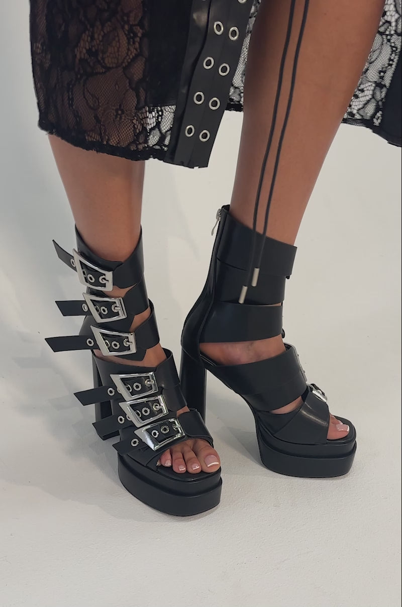 A video of a person wearing the AKIRA GOLD ALBERIC BLACK CHUNKY PLATFORM SANDALS. 