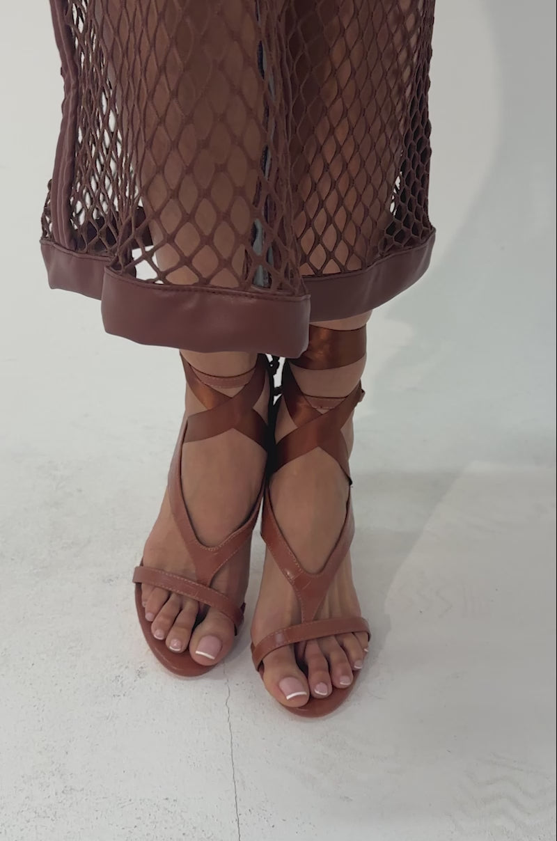 A video of a person wearing the AKIRA GOLD SIEGER BROWNPATENT WRAP UP BALLERINA STILETTO SANDAL.