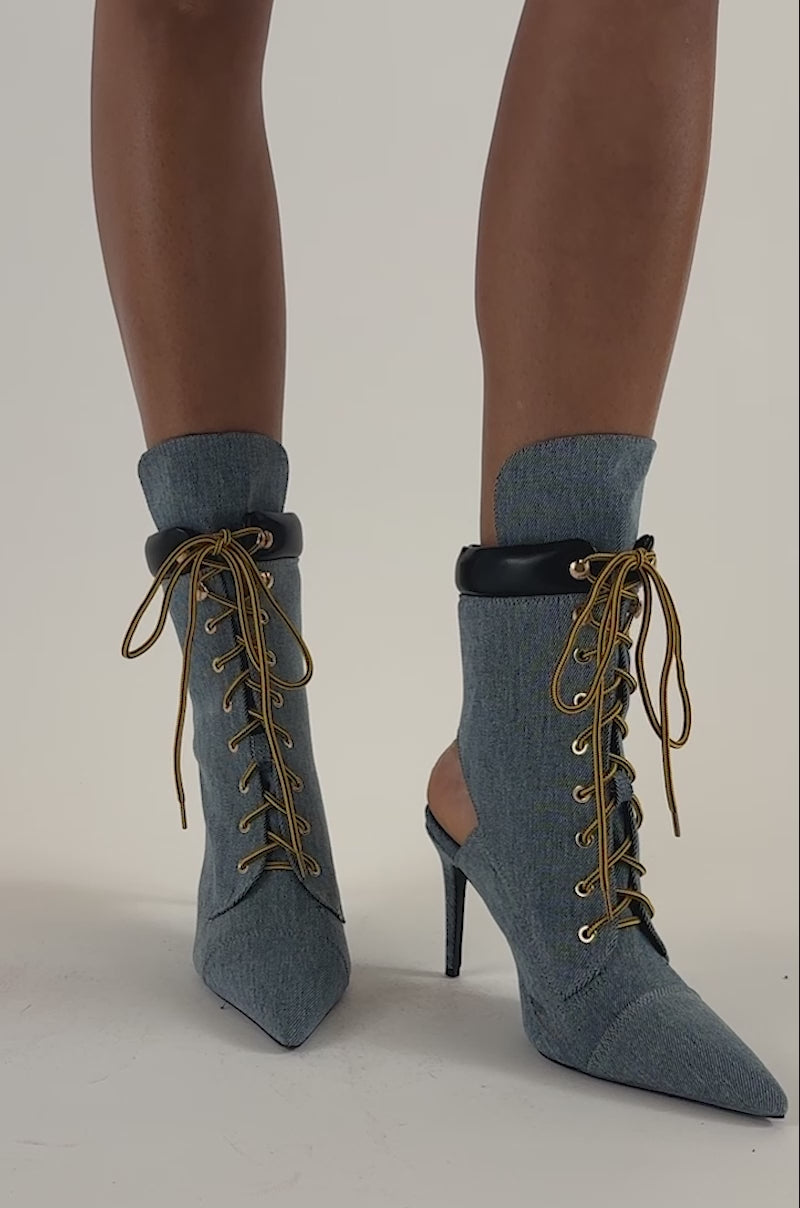 Video of a woman modeling the AZALEA WANG XIOMARA DENIM BOOTIE—blue lace-up heeled boots featuring bold yellow laces.