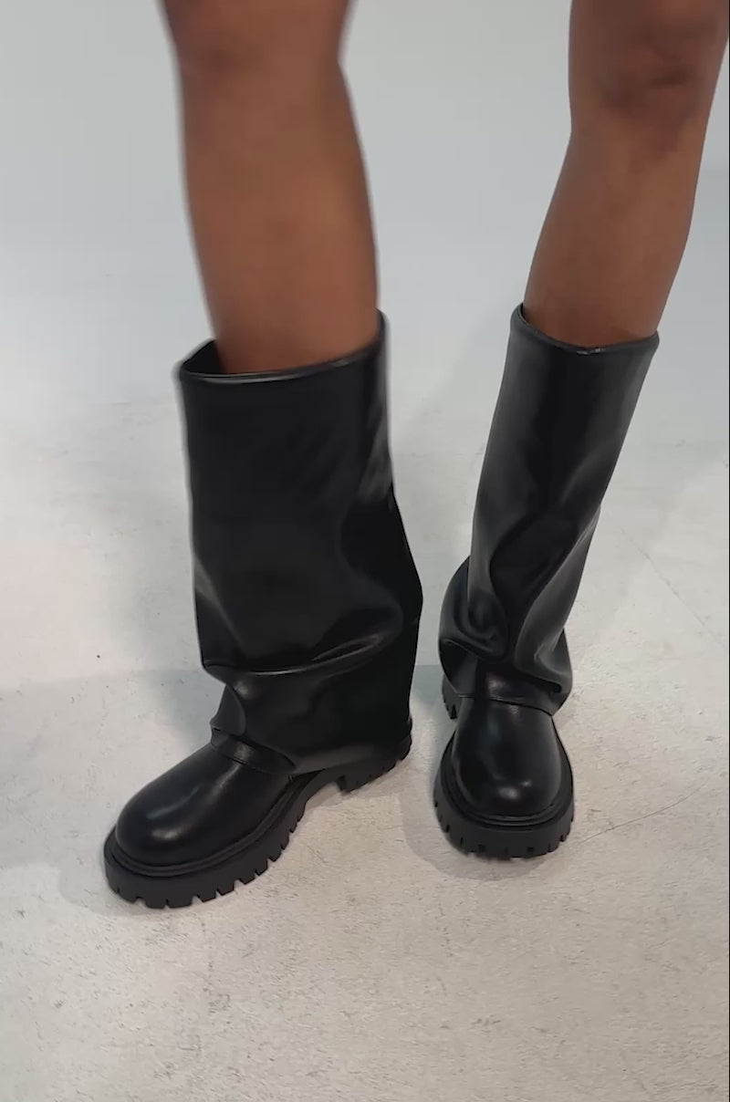 Video of woman modeling the AZALEA WANG HOYT BLACK FLAT RUCHED BOOTIE against a plain light background.