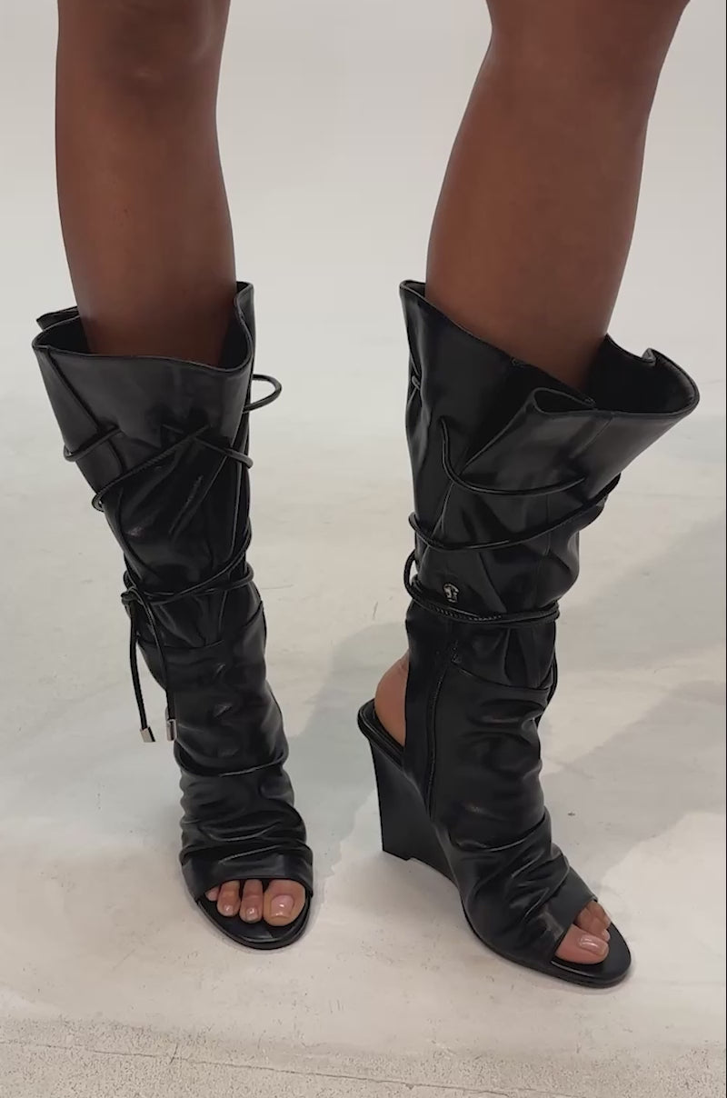 Video of woman modeling the AZALEA WANG VAILEN BLACK OPEN TOE SLOUCHY BOOTIE against a plain light background