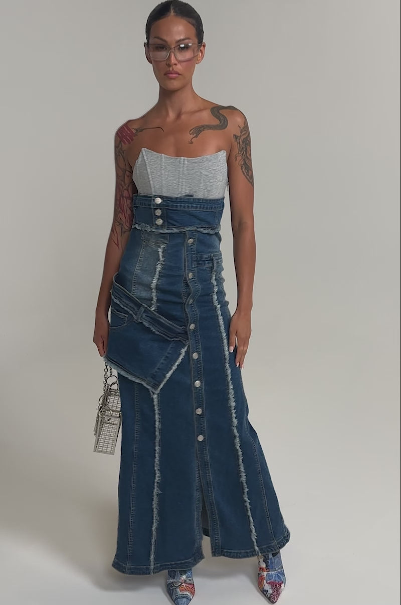 Video of woman modeling the UP TO NO GOOD DISTRESSED DENIM MAXI DRESS styled festival-ready with blue open-toe heels and a metallic mini handbag.
