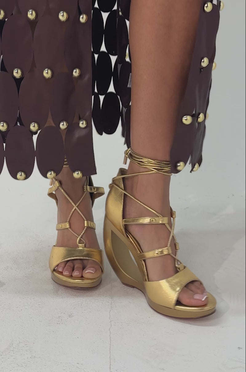 A video of a model wearing AKIRA GOLD RACHNA GOLD WEDGE OPEN TOE SANDAL.