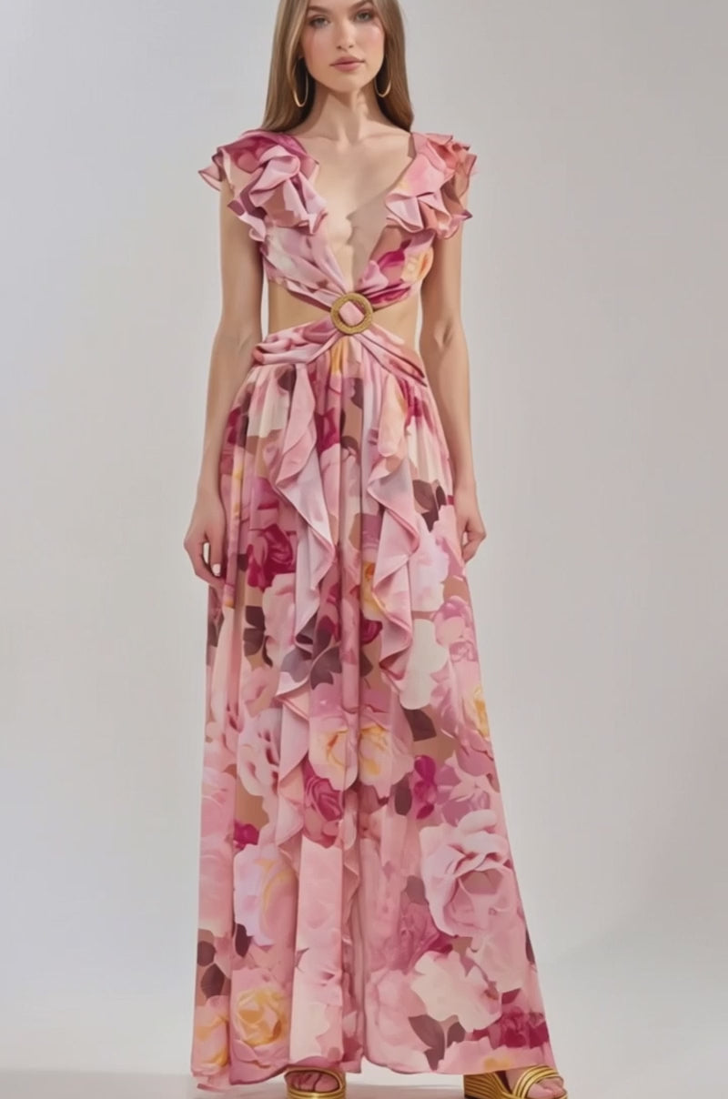 Video of woman modeling the LOVE YOU LATER FLORAL MAXI DRESS, featuring ruffles, a deep V-neck, cut-out sides, and a high slit. Styled with tan platform heels, she stands against a plain light background—ideal for spring occasions.