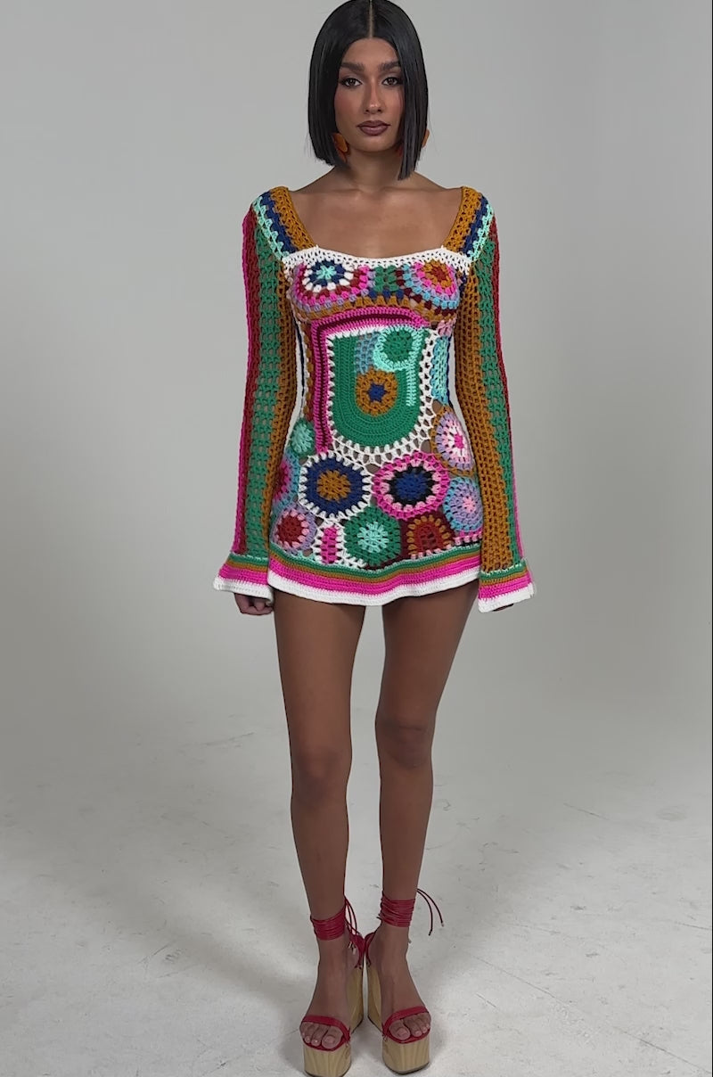 Video of woman modeling the CROCHET ALL DAY COLORBLOCK MINI DRESS, a vibrant crochet mini dress with bold geometric and floral patterns, posing against a plain light background.