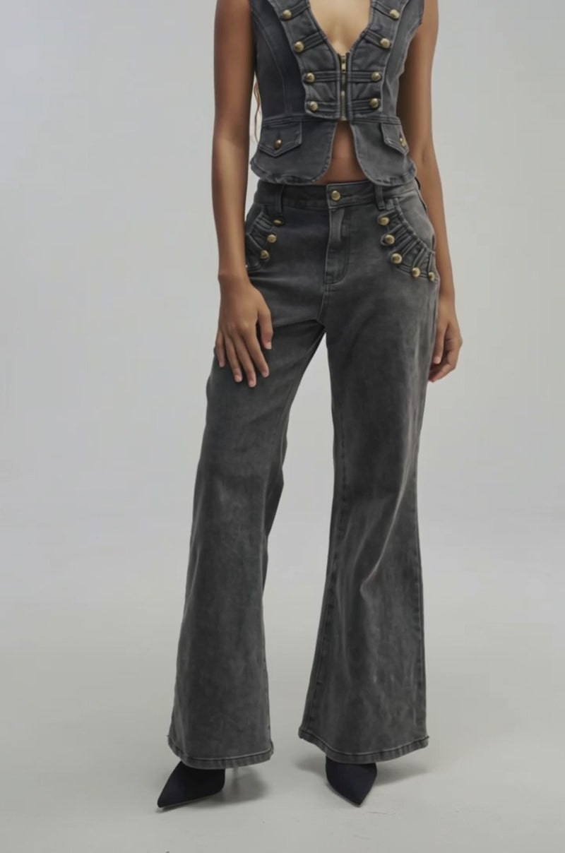 Video of a woman modeling the AHEAD OF THE CURVE MILITARY DENIM TOP—a cropped black denim piece with gold buttons and a front zipper.