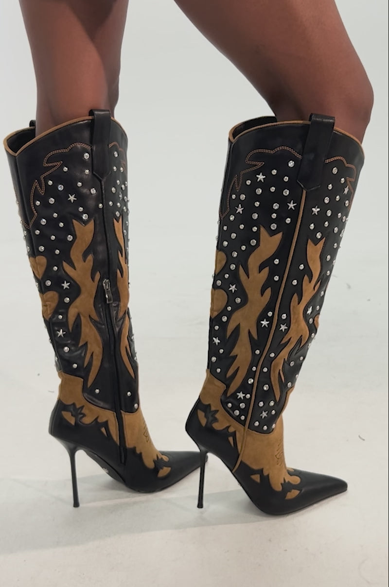 Video of woman modeling the AKIRA GOLD KALPANAS BLACK MULTI STILETTO WESTERN BOOT, featuring bold black and brown flame designs with silver studs