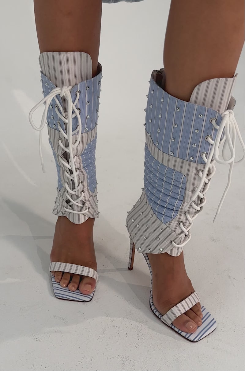 A video of a person wearing the AKIRA GOLD ALBERTO BLUE STRIPE PATTERN GLADIATOR STILETTO sandals.