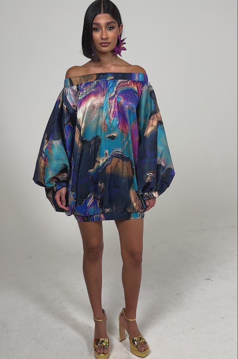 A video of a woman wearing the OUT FOR BRUNCH PATTERNED MINI DRESS, featuring off-the-shoulder balloon sleeves and a vibrant abstract swirl print.