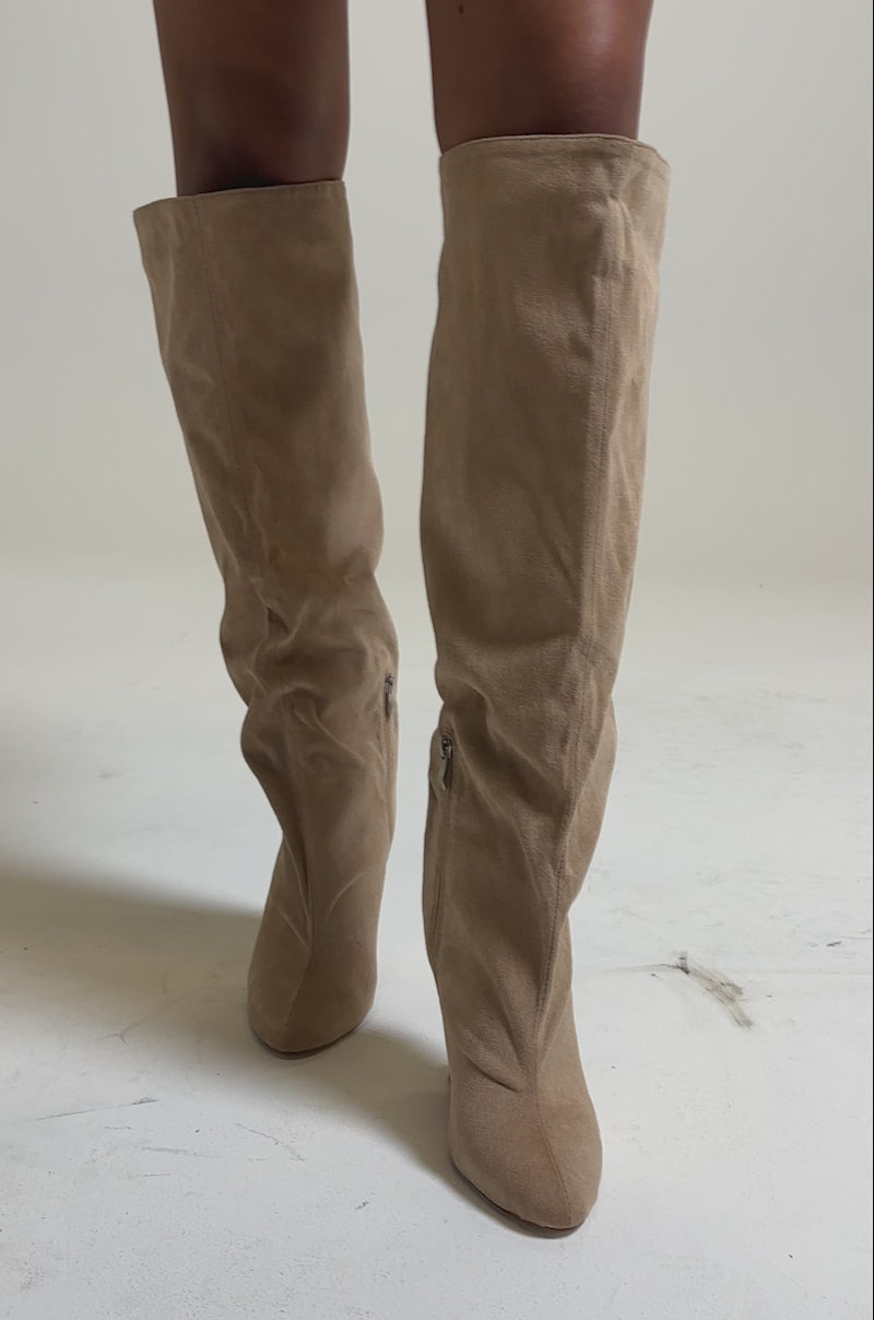A video of someone wearing the AZALEA WANG VINCE NUDE FAUX SUEDE WEDGE BOOT—knee-high with a slouchy fit and pointed toe—paired with a floral skirt.