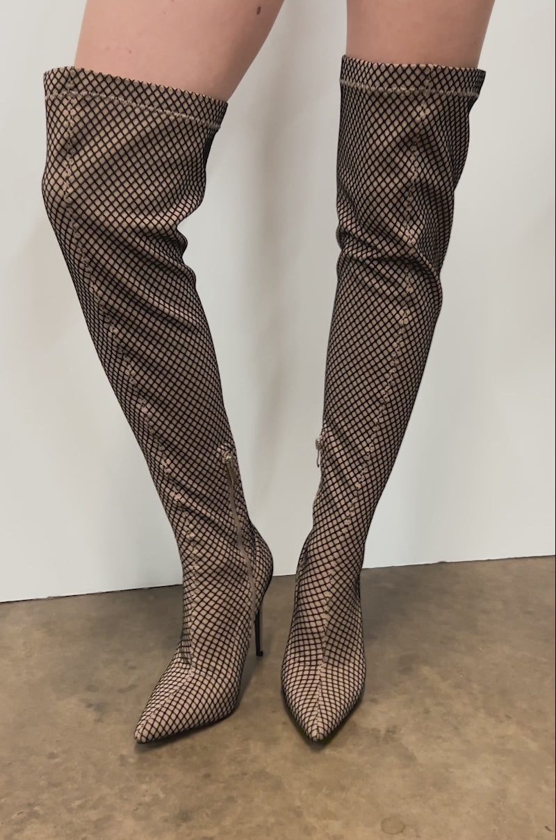 Video of person modeling the AZALEA WANG FREEDAH NUDE FISHNET LOOK STILETTO BOOT. It features a knee-high length, pointed toe stiletto with chic black fishnet mesh over a light beige base, delivering a stylish nude look.