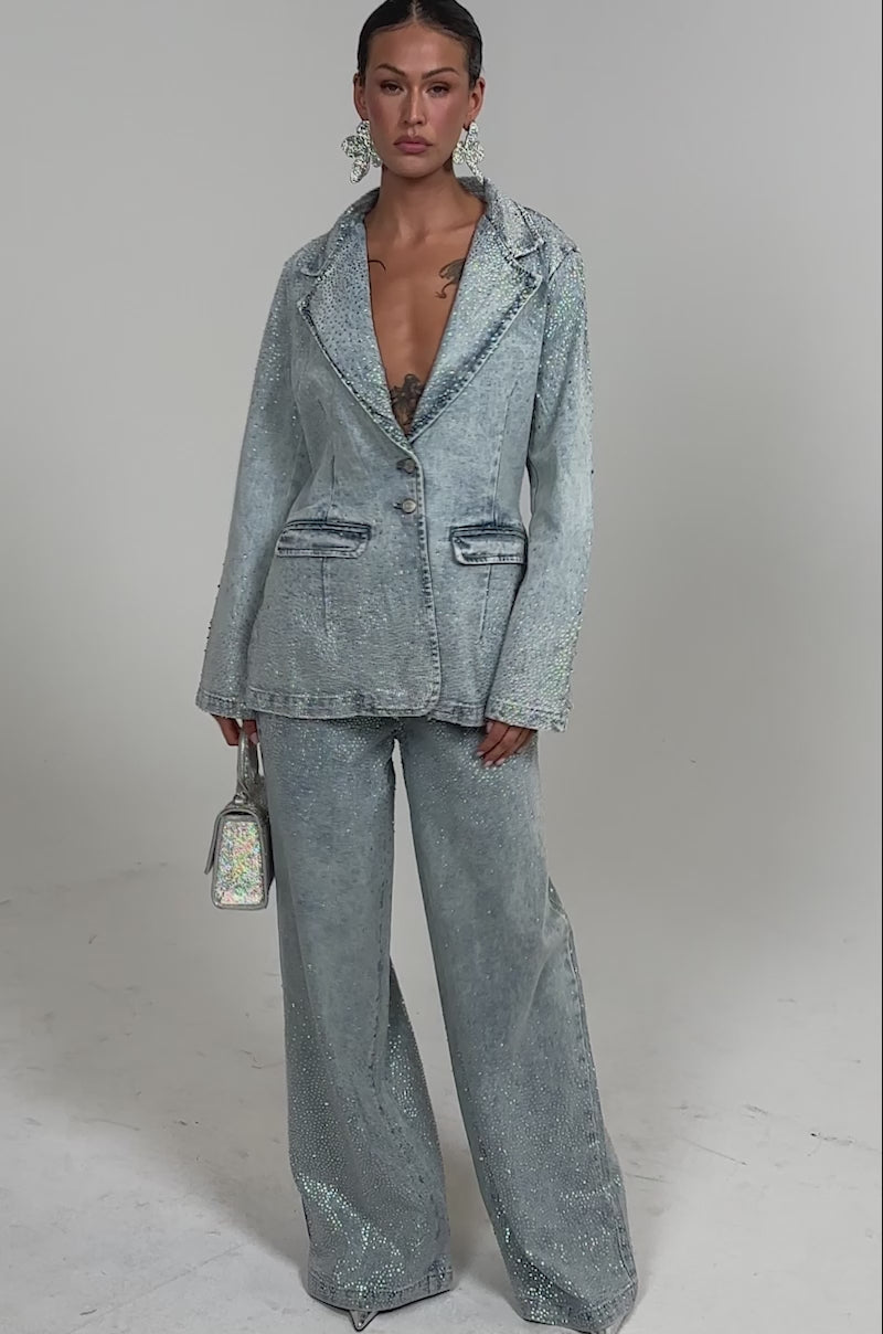 Video of woman modeling the LIGHTS OUT RHINESTONE WIDE LEG DENIM with a matching blazer, large earrings, and a glittery handbag for chic, trend-driven styling.