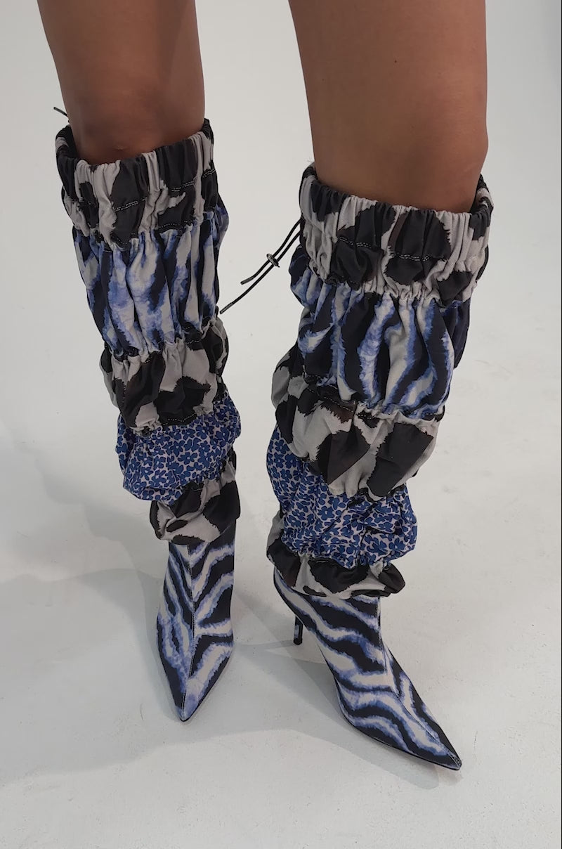 A video of a person wearing the AKIRA GOLD ELODIE BLUE MULTI PATCHWORK BOOT.