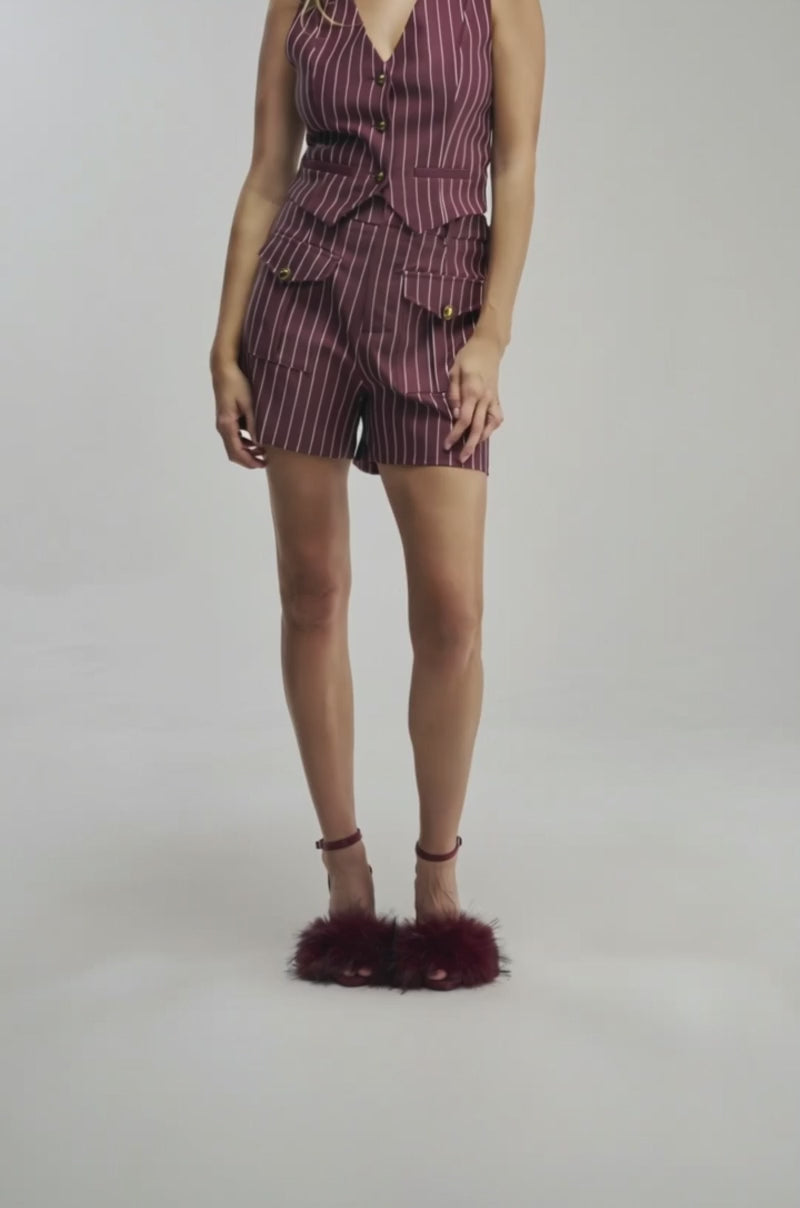 Video of a woman modeling the SUNDAY PINSTRIPE SHORTS IN BURGUNDY featuring a high-rise waistband and matching burgundy pinstripes. 