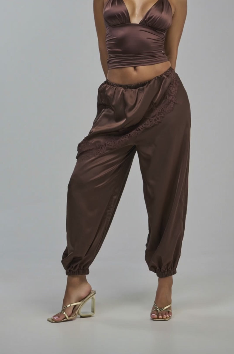 Video of a woman modeling the PARTY IN THE FRONT BALLOON PANT WITH SKIRT OVERLAY. The balloon pants are accented with an asymmetrical, lace-trimmed skirt overlay. 
