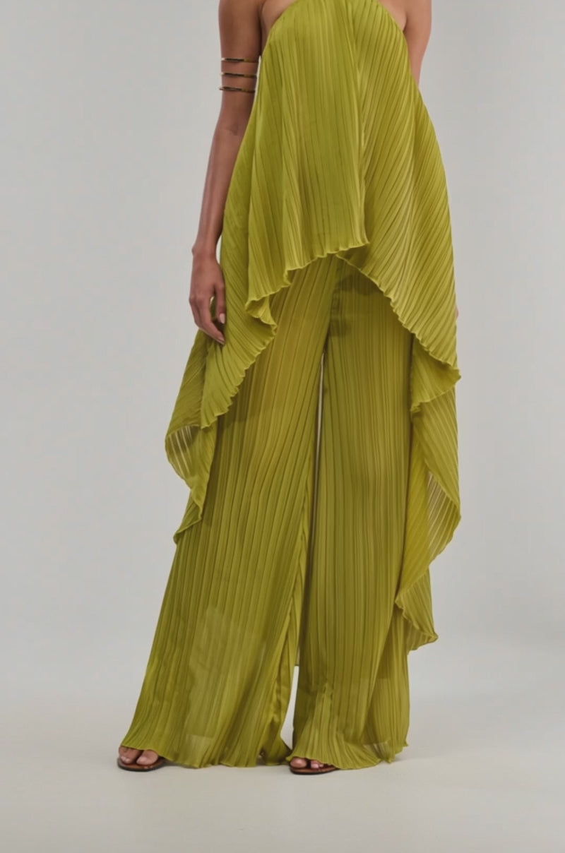 Video of a woman modeling the CRUSHIN ON YOU BLOUSE IN CHARTREUSE, a loose-fitting, pleated top with a halter neckline. Draped, asymmetrical layers evoke resort style.