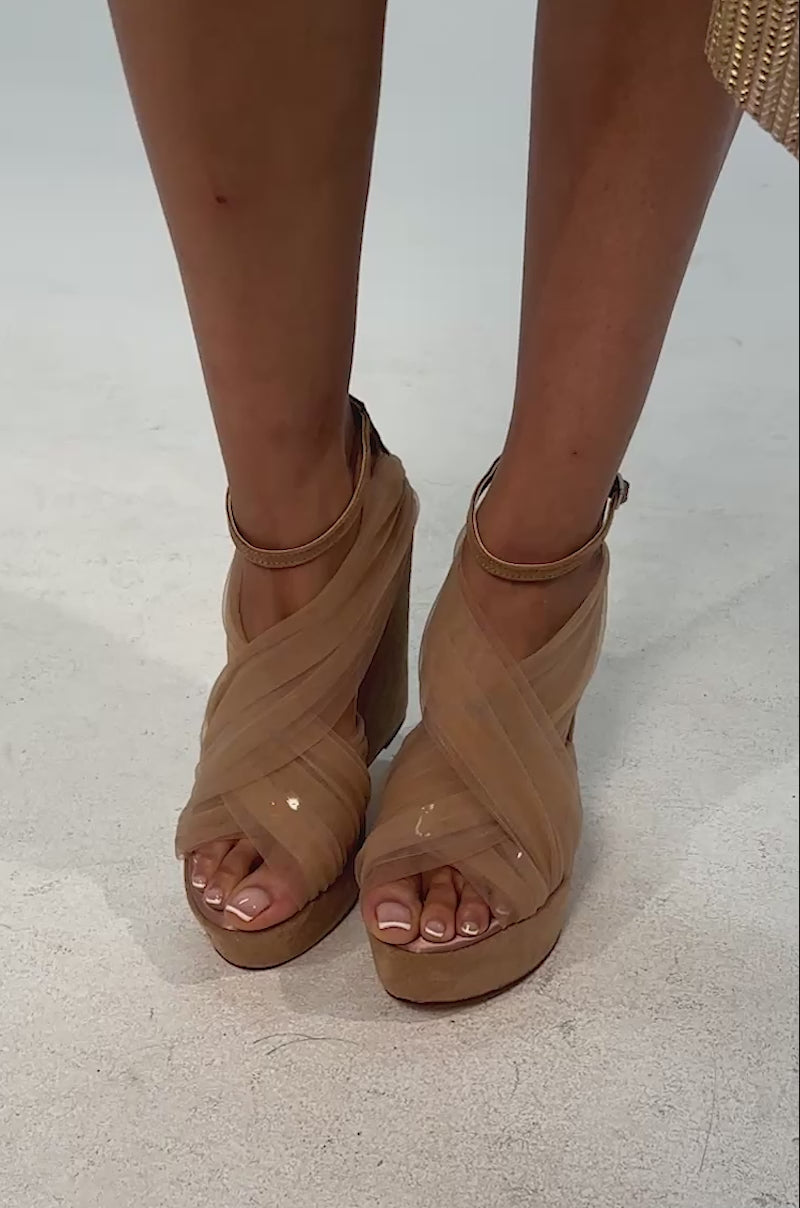 Video of woman modeling the AZALEA WANG BALLERINE Nude Faux Suede Wedge Sandals with crisscross straps, a suede platform wedge heel, and subtle tulle wrap-around accents, set against a light background.