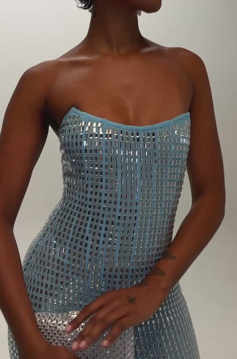 Video of a woman modeling the THE WOW FACTOR STRAPLESS RHINESTONE MINI DRESS—a fitted blue mesh bodycon mini dress adorned with a grid of shiny silver rhinestones.