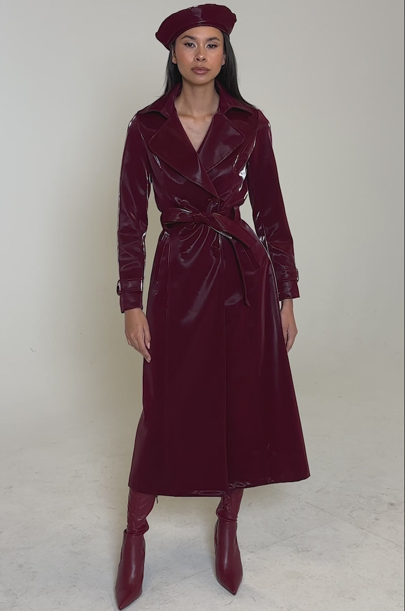 Video of woman modeling the SANDO LIQUID VELVET TRENCH IN BURGUNDY with a matching belt and beret