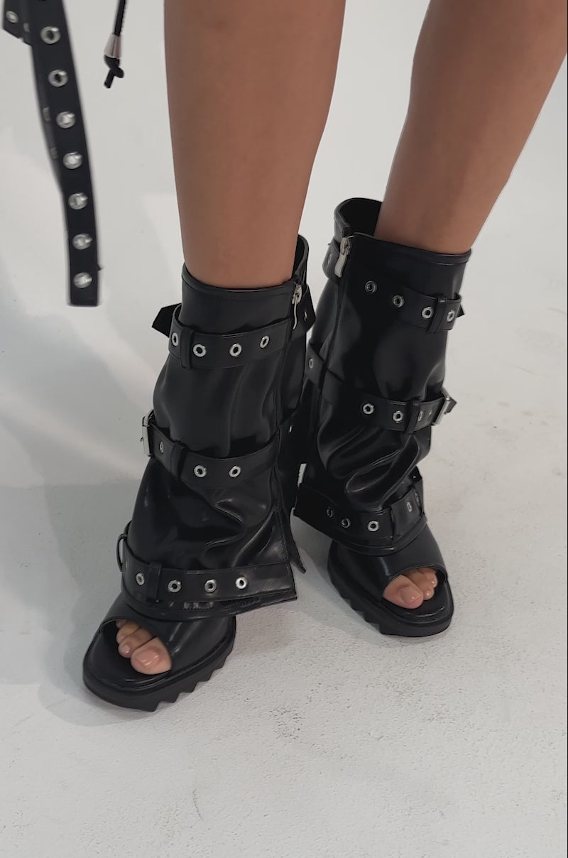 A video of a person in the AZALEA WANG AMES BLACK PU HARDWARE EMBELLISHED STILETTO BOOTIES.