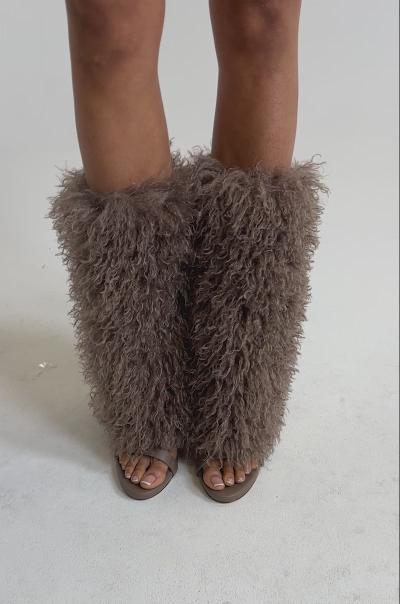 A video of a model wearing the CLOUD NINE TAUPE FUR OPEN TOE BOOT.