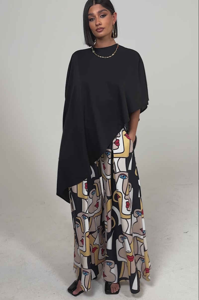 A video of a woman in the FACES EVERYWHERE TROUSER featuring an abstract face print in beige, yellow, red, blue, and white.
