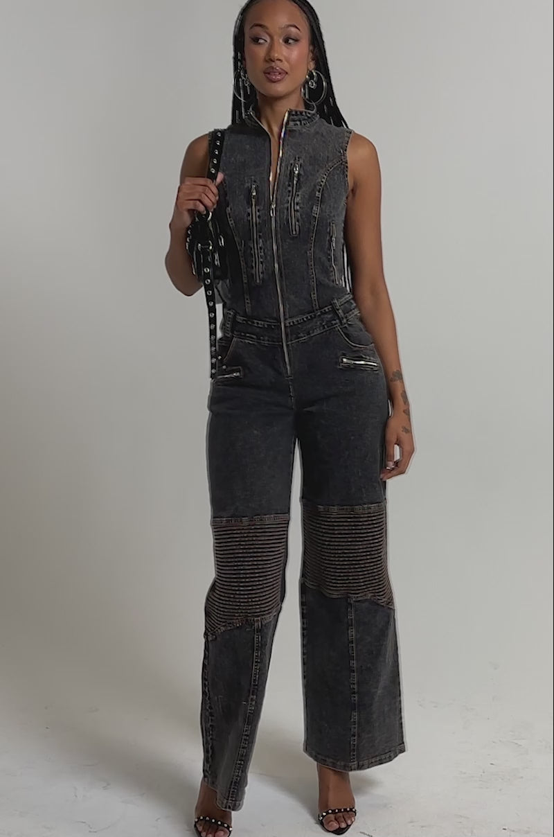 A video of a woman in the CAMILLA SLEEVELESS DENIM JUMPSUIT, featuring moto-style textured leg panels.