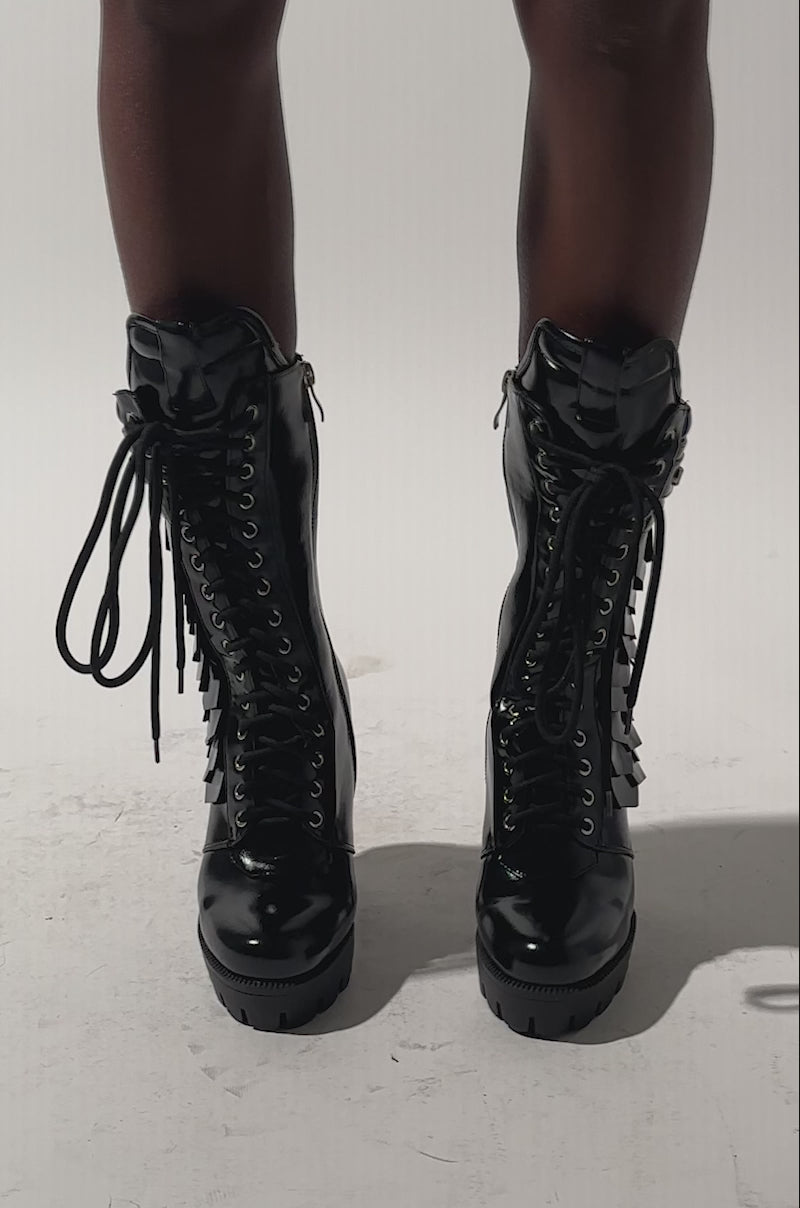 A video of a person wearing AZALEA WANG GERNOT Black Lace Up Scaled Platform Booties.