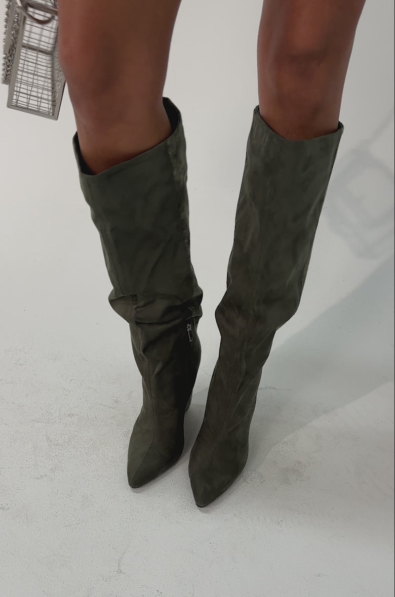 Video of woman modeling the AZALEA WANG GIANNA OLIVE TWO TONED BOOT styled with a small metallic cage-style handbag.