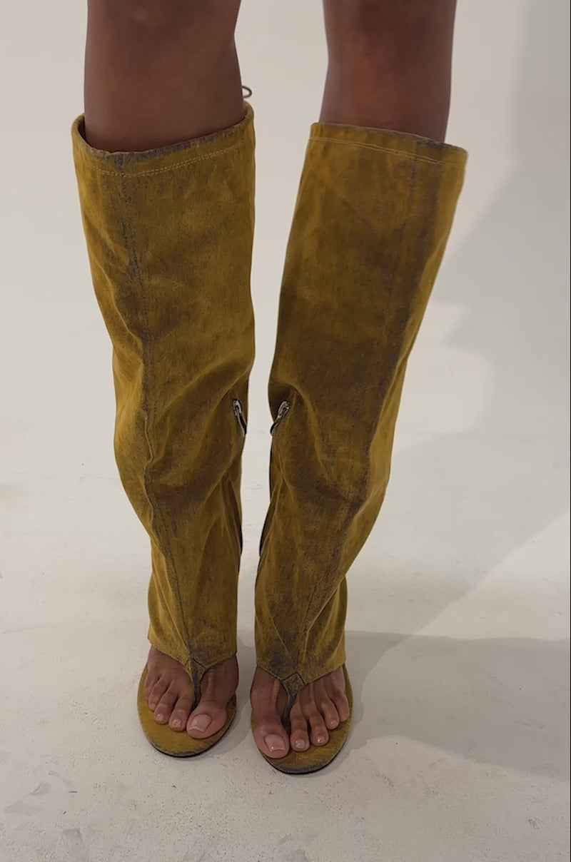 Video of a woman modeling the AZALEA WANG XYYLAH MUSTARD WEDGE GLADIATOR SANDAL—slouchy, knee-high sandals in mustard yellow with wedge heels, zippers, and laces.