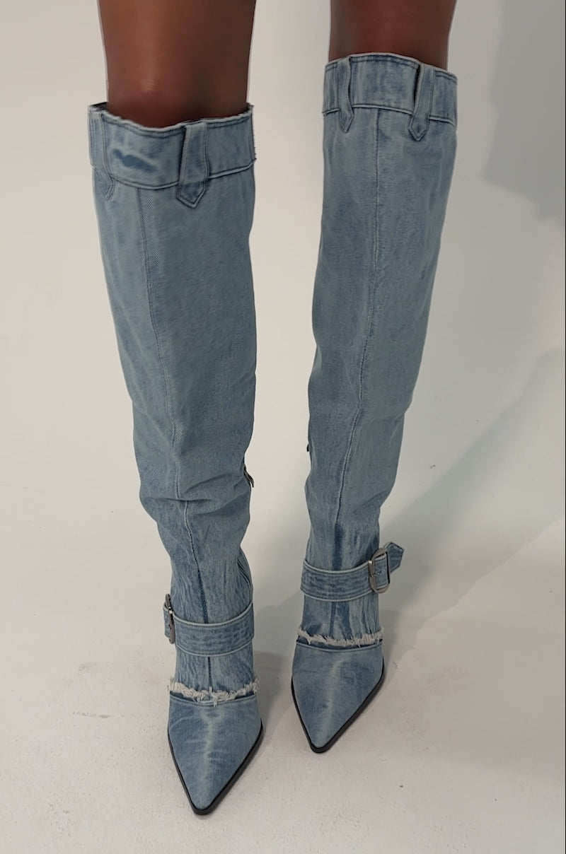 Video of woman modeling the AKIRA GOLD DURANGO DENIM STILETTO PANT LOOK BOOTS featuring pointed toes, buckles, zippers, and an over-the-knee silhouette.