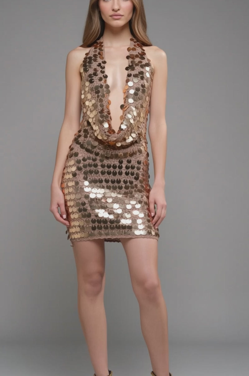Video of woman modeling the ARIEL SEQUIN CROCHET MINI DRESS IN GOLD. The halter mini dress is covered in shiny gold sequins—an ideal choice for festivals.