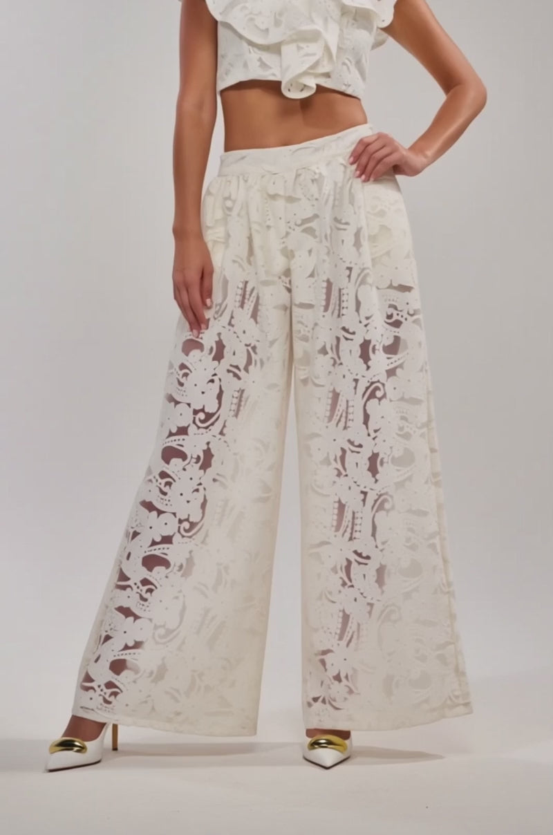 A video of woman wearing the EMMA EMBROIDERED CROPPED BLOUSE and matching high-waisted lace pants.