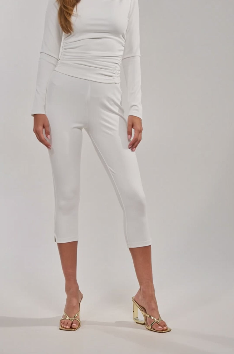 A video of a model wearing the MODEL OFF DUTY CAPRI with a matching long-sleeve top and gold open-toe heels.