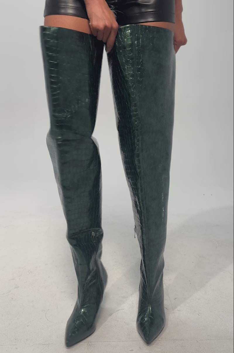A video of a model wearing the AZALEA WANG HALINA Dark Green Croc Stiletto Boot. It is a tall, pointed toe thigh high crafted from faux leather.