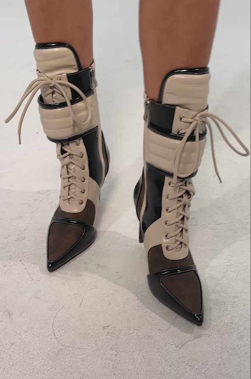 Video of woman modeling the AZALEA WANG AMADA Chocolate Colorblocked Sporty Bootie—high-heeled lace-up boots in beige, brown, and black with pointed toes and ankle straps.