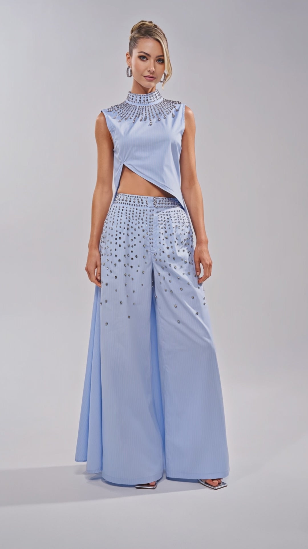 Video of woman modeling the STAR OF THE NIGHT POPLIN TROUSER in light blue, featuring a wide-leg silhouette and silver embellishments scattered from waist to upper thighs