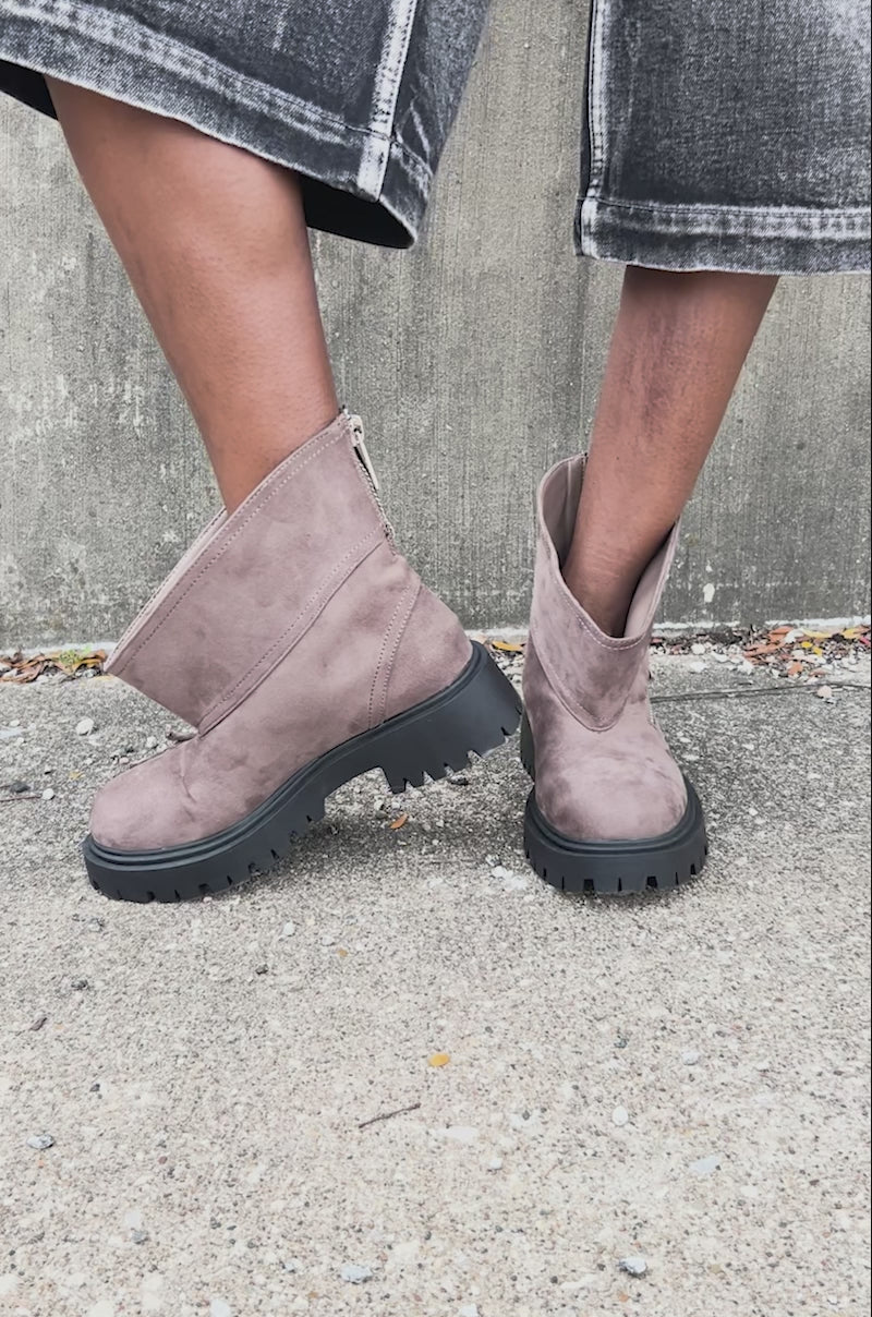 Video of woman modeling the AZALEA WANG MOHSEN MOCHA COMBAT BOOTIE featuring brown faux suede, a chunky black heel, side zipper, slanted upper design, and exposed zipper detail for a rugged, modern look.