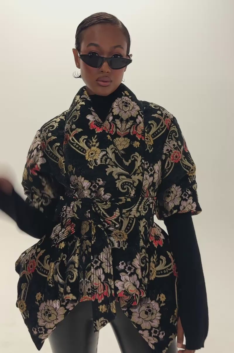 Video of a woman modeling the MONET JACQUARD PEPLUM PUFFER—a statement jacket with an artful jacquard texture and a flattering peplum silhouette.