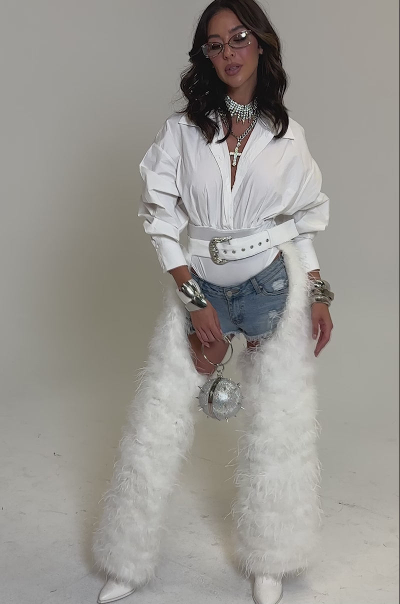 Video of woman modeling the IM PERFECT FEATHER CHAPS with a white shirt and denim shorts