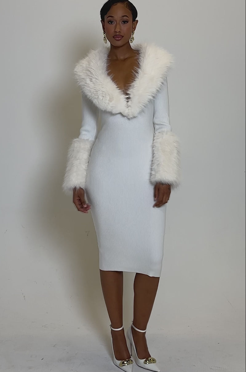 Video of woman modeling the CELINE SWEATER MIDI DRESS WITH FUR TRIM— a fitted, ribbed knit midi dress featuring plush white fur on the collar and cuffs.