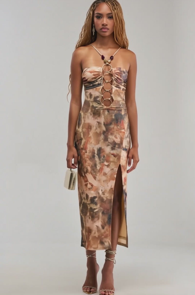 Video of a woman modeling the CALL ME ICONIC BEADED MIDI DRESS, featuring brown and tan tie-dye with circular cutouts.