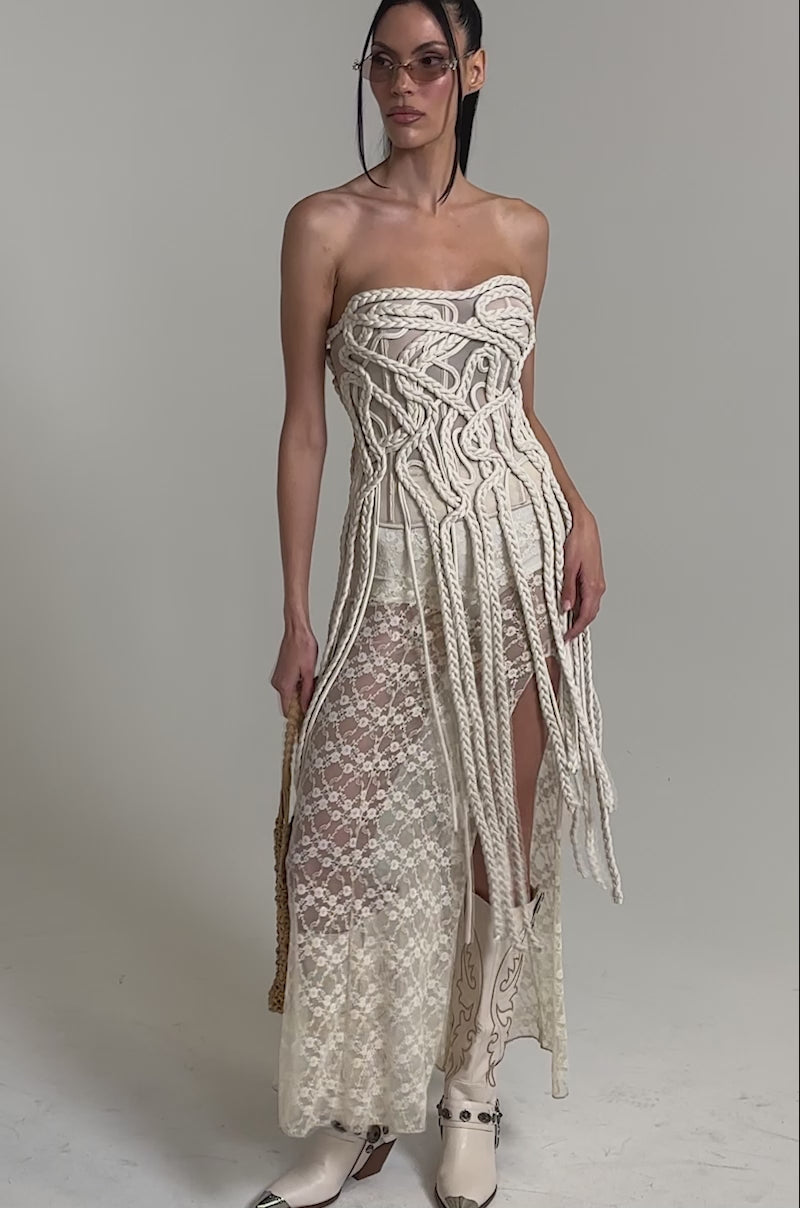 A video of a woman in the NEVER LOST TASSEL MESH CORSET, featuring a strapless sweetheart neckline and subtle structural boning, exudes timeless elegance.