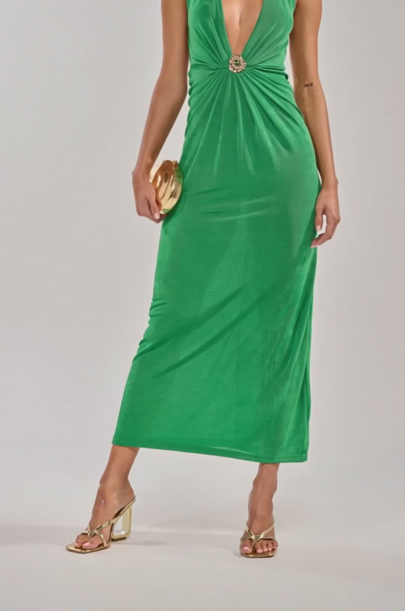 Video of woman modeling the SEE IT TO BELIEVE IT MESH MAXI DRESS in green, styled with gold open-toe heels and a small gold clutch, standing against a light background—an ideal chic summer vacation look.
