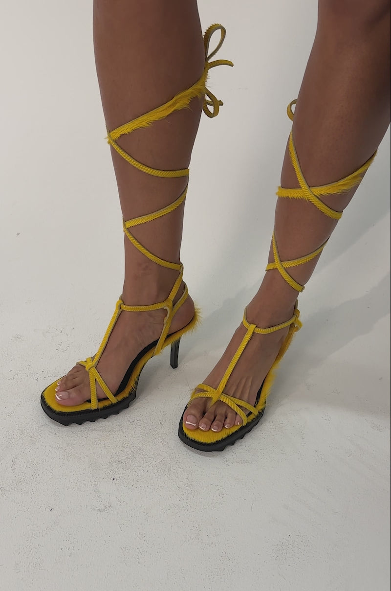 Video of woman modeling the AKIRA GOLD RAVZA YELLOW CALF HAIR STRAP HIGH HEEL STILETTO SANDALS 