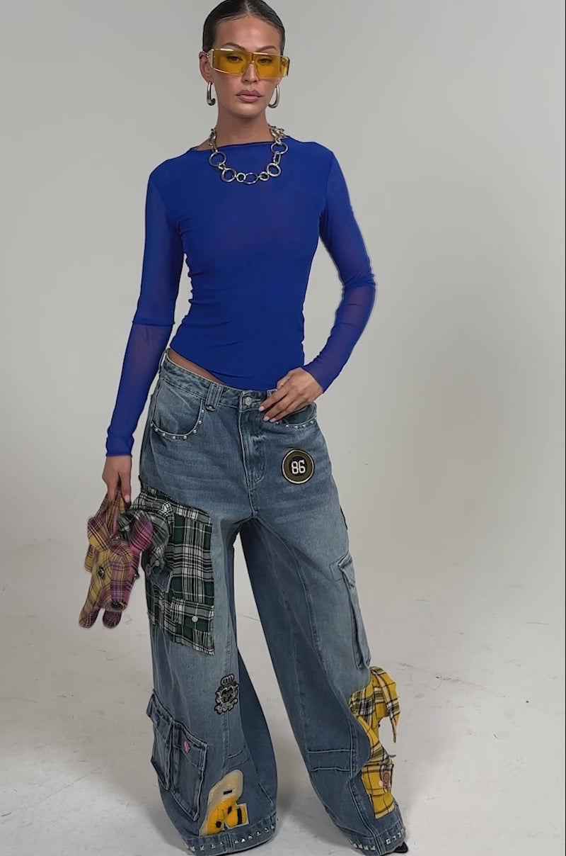 Video of woman modeling the FEELING THE WAVES RELAXED DENIM and holds a plaid stuffed animal purse.
