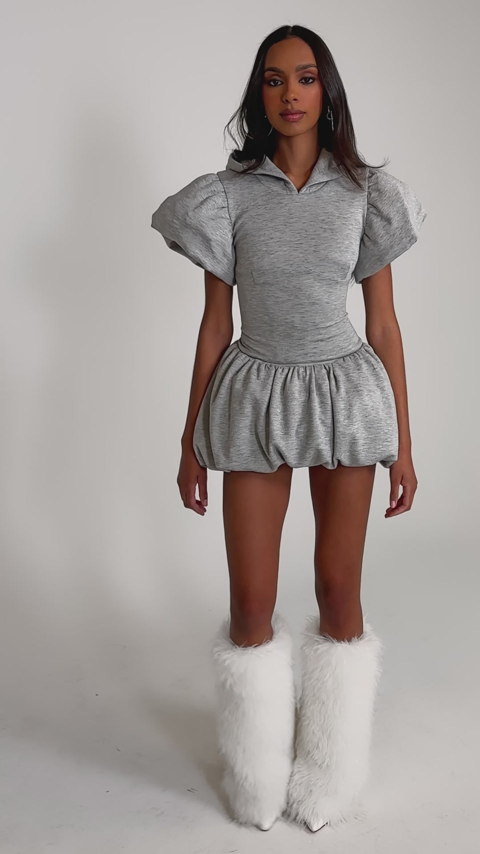 Video of woman modeling the GIRL POWER FRENCH TERRY MINI DRESS—a light gray piece featuring dramatic puffy sleeves and a voluminous bubble skirt—standing against a plain light background.