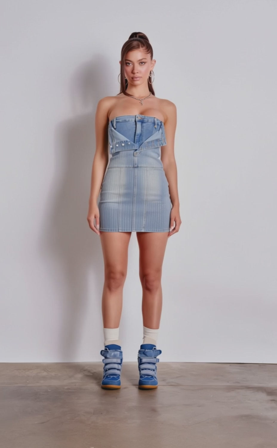 A video of a woman in the BUTTONED UP BEDAZZLED MINI DENIM DRESS, styled like an upside-down jean jacket. 